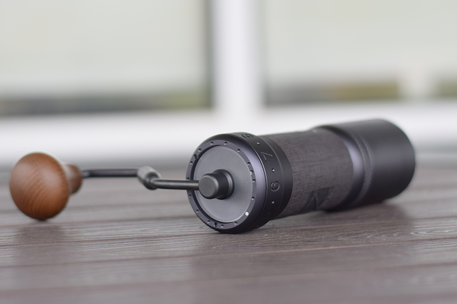 Portable coffee mill handle and wooden ball detail.